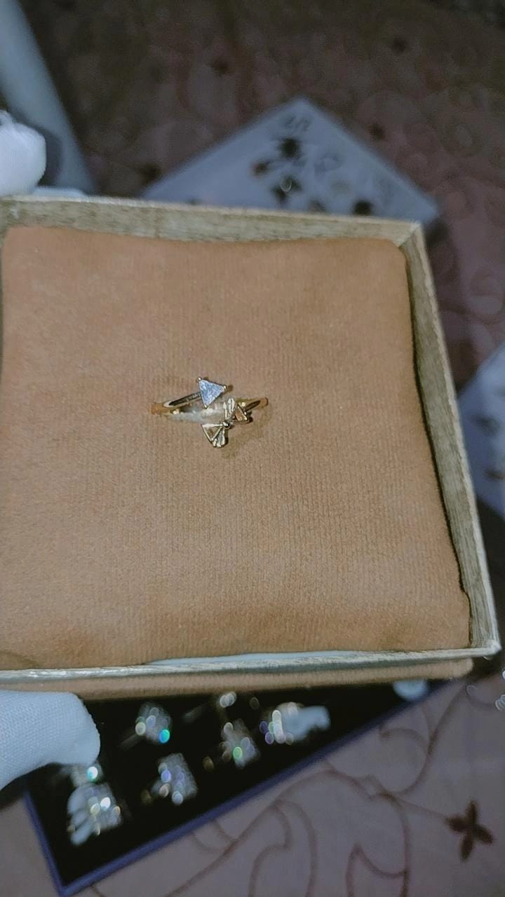 This delicate gold-tone open adjustable ring features an asymmetric wrap-around design.