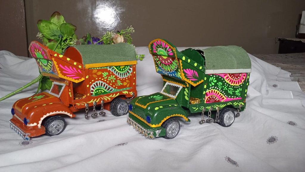 Handcrafted mini Pakistani truck art models featuring vibrant, hand-painted floral motifs and traditional embellishments.