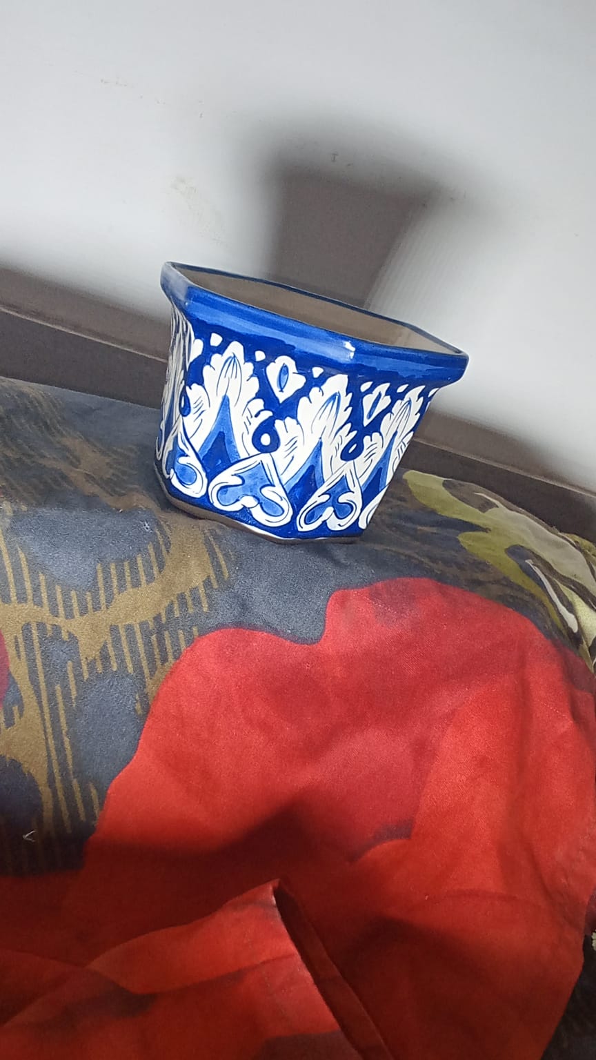 hand-painted Multan blue pottery (Kashi Kari) planter features traditional cobalt blue and white floral artwork with a glossy glazed finish. Its hexagonal shape makes it a versatile piece for home decor, plant display, or tabletop accenting.