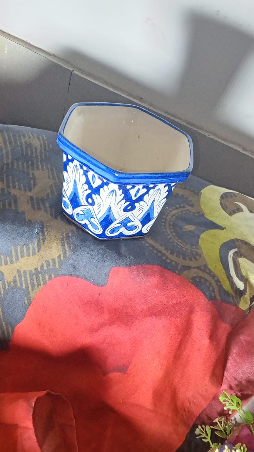 hand-painted Multan blue pottery (Kashi Kari) planter features traditional cobalt blue and white floral artwork with a glossy glazed finish. Its hexagonal shape makes it a versatile piece for home decor, plant display, or tabletop accenting.
